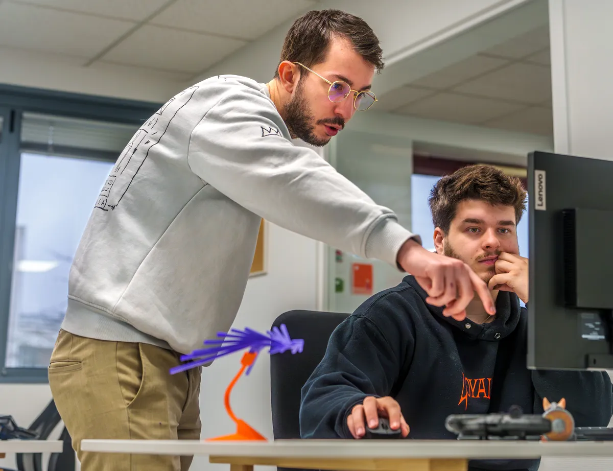 Deux développeurs web EcloLINK collaborant lors d'une revue de code dans les locaux de l'agence